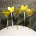 Dettaglio di cinque decorazioni per torta a forma di cuore dorato su stecchi in legno. - Cuore Dorato / 5 Pezzi