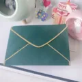 Detail view of a dark green pearlescent envelope with elegant gold foil border - 11x16cm / Dark Green