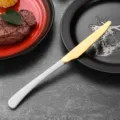 Elegant stainless steel steak knife with a gold blade and a premium white handle - Dinner Knife / White
