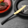 Premium gold and black stainless steel steak knife with serrated blade for fine dining - Dinner Knife / Black
