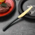 Premium gold stainless steel steak knife with elegant black handle and serrated blade. - Dinner Knife / Dark Green