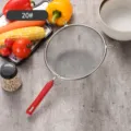 Edelstahlsieb mit feinem Maschennetz und ergonomischem rotem Griff zum Durchsieben - 20cm
