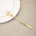 Eleganter goldener Edelstahl-Abendessen Gabel auf einem dekorativen Teller und Platzset - 304 Klasse Koreanische Gabel mit langem Griff / Gold