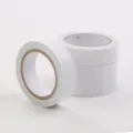 Primo piano di rotoli di nastro biadesivo bianco con anima in carta e finitura pulita. - Bianco
