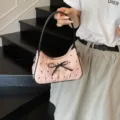 Modische rosa Halbmond-Schultertasche mit schwarzer Schleife und K-Musterdruck - Rosa