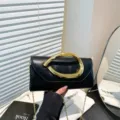 Elegante schwarze Abendtasche mit großem goldenem Metallgriff und feinem Kettenriemen - Schwarz