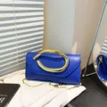 Elegante blaue Abendtasche für Damen mit skulpturalem Goldgriff und feiner Kette - Blau