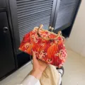 Red evening clutch with wave embroidery, bamboo handle, and gold chain strap - Red