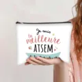Hand holding a white canvas zipper pouch featuring French 'Meilleure ATSEM' text print - French Style (ATSEM 1)