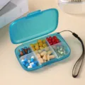 Portable 6-grid pill box with lanyard, ideal for travel medicine and vitamin organization. - Blue