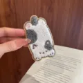 Macro view of a soft plush cartoon cat embroidery patch for hair styling and accessory. - Grey Spotted