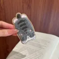 Detailed macro view of a soft grey and white fuzzy cartoon cat hair patch sticker accessory - Gray