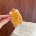 Detailed view of a soft orange chenille cartoon cat patch for fringe hair styling - Turmeric