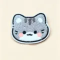 Close-up of cute plush cat-head shaped fringe hair sticker with soft texture - Silver Tabby Cat Fringe Pad