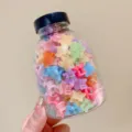 Detail view of various colorful star-shaped mini hair claw clips in a clear storage jar - 1# Jelly Star Style