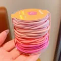 Primer plano de gomas elásticas rosas degradadas para niñas en un bote claro - 48 Piezas por Juego / Tonos Rosados