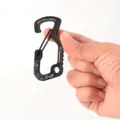 Nahaufnahme Detail des schwarzen Aluminium Karabiners mit Federverschluss und Werkzeugloch. - Schwarz