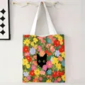 Bolsa de lona con un estampado de flores vibrantes y una ilustración de gato negro. - Ilustración Floral Densa Gato Negro / 34x39cm