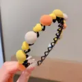 Cute children's zigzag headband with colorful fabric pom-poms and yellow heart accents - Hemisphere Style / Yellow