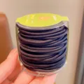 Vista detallada de gomas elásticas negras para el pelo en un bote de plástico claro - 48 Piezas por Juego / Serie Negra