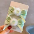Detailed macro view of French style hair clips featuring soft fur and heart gems - Bowknot Hair Clip Pair / Green