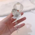 Close-up of elegant floral hair claw clip with faux pearl tassel details. - Flower Tassel