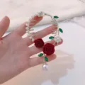 Detailed view of elegant bun hair clip with red velvet roses and dangling pearl tassels - Red Rose