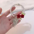 Close-up of an elegant butterfly and red rose bird nest hair claw clip with pearls and crystals - Rose Butterfly