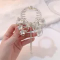 Detail view of white flower butterfly hair clip with long rhinestones tassel and pearls. - Bow Combination