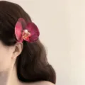 Close-up detail of an elegant purple orchid flower hair clip with a pearl accent. - Pearl Hair Clip / Red