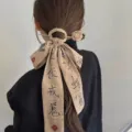 Close-up of elegant ancient style hair ribbon with Chinese calligraphy and gold hairpin accessory. - Rose Hair Stick With Calligraphy Ribbon