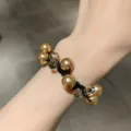 Elegant champagne pearl and crystal bead dual-use hair tie bracelet on model's wrist - Champagne Pearl Hair Tie