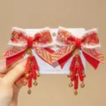 Close-up of traditional Chinese New Year red bow hair clips with tassels and bells - Firecracker Fortune Style (D169----5)