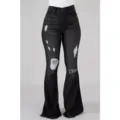 Detailed close-up view of high-waist black distressed bell-bottom jeans featuring ripped knee design. - XS / Black