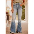 Close-up view of distressed blue flare jeans featuring high waist and frayed hems on wooden floor. - 5XL / Light Blue