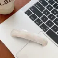 Detail of an elegant marbled acetate hair clip placed on a modern silver laptop. - Mermaid White