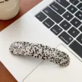 Detailed view of elegant speckled acetate hair clip on a modern laptop keyboard surface - Spotted Pattern