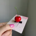 Cute 3D red cherry fruit hair clip for women attached to a pink jewelry display card - 2 Pieces/Pack / Cherry