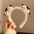 Close-up of cute plush panda heads on a soft fuzzy white headband hair accessory - Black & White Panda