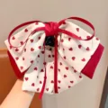 Detail showing a cute bow hair claw clip with red heart patterns - Red White Hearts