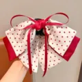 Macro view of a sweet red polka dot bow hair claw clip for little girls' styling - White with Red Polka Dots