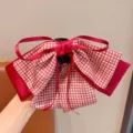 Gros plan d'une pince à cheveux crabe avec nœud à carreaux rouges - Carreaux Rouges