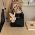 Schwarze Bucket-Bag aus Leder mit Litschistruktur, Schloss und süßem Bärenanhänger - Mit Anhänger / Schwarz
