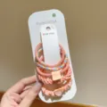 Set aus fünf rosa elastischen Haargummis mit Herz- und Smiley-Anhängern auf Karte - 5er-Pack / Dunkelrosa
