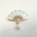 Close-up detail of elegant fan-shaped brooch with white enamel, rhinestones and pearl. - White Fan (XZ380) / White