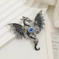 Dettaglio di una spilla a drago steampunk con occhio blu e decorazioni a ingranaggi - Nero (XZ361)