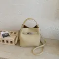 Elegante beige Eimertasche mit Lychee-Maserung, silbernem Schloss und Tragegriff. - Einzelne Tasche / Gelb