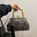 Vintage-Handtasche mit Paisleymuster, Bambusgriff und elegantem schwarzem Quastenanhänger - Schwarz
