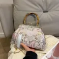 Vintage-Beuteltasche mit Paisley-Muster, Bambusgriff und eleganter weißer Quaste - Silber