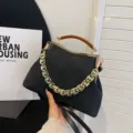 Elegant black textured striped handbag with amber acrylic handle and gold chain strap - Black